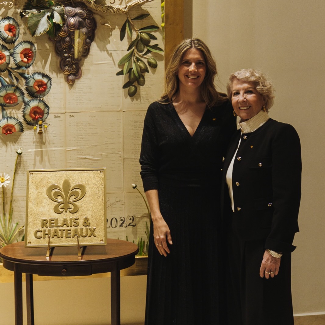 Susana Balbo and her daughter Ana beside the Relais & Châteaux plaque at the Winemaker's House